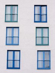 Six blue windows on a white wall