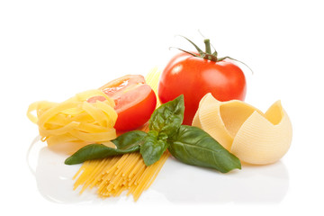 Pasta, tomato and basil leaves on white background