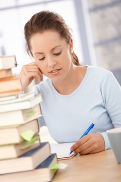 Attractive girl studying at home for exam