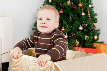 Baby boy smiling in a big Christmas-box