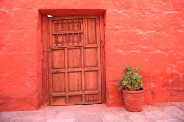 Red wall with old decorative stone door.