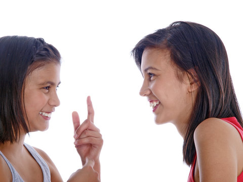 two happy teenage girls communicating in sign language