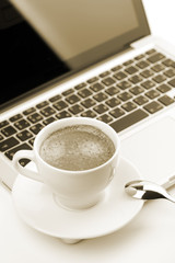 Cappuccino cup on laptop