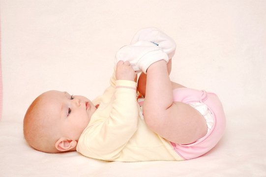 cute baby is playing with feet