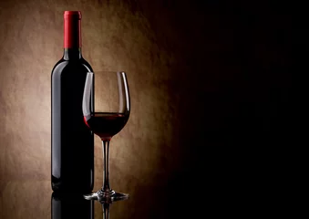 Foto op Plexiglas fles met rode wijn en glas en druiven © Igor Klimov