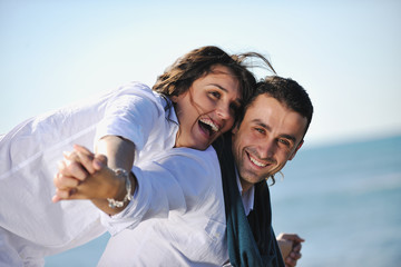 Obraz premium happy young couple have fun at beautiful beach