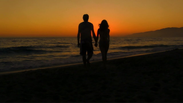 Young couple walks into sunset - HD