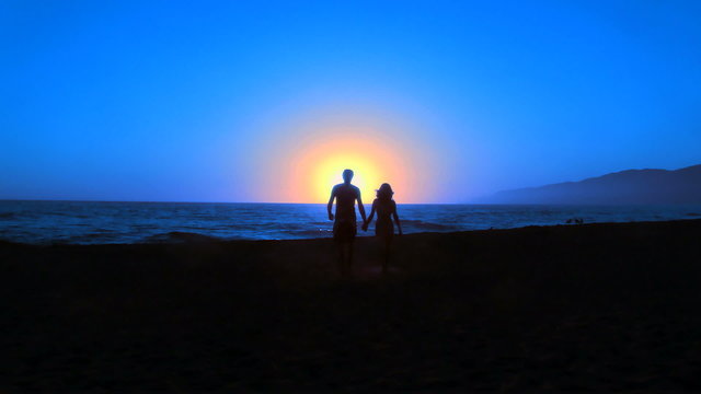 Couple on beach walks into sunset - HD