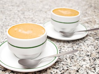 2 cups of coffee, on stone table