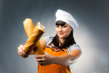woman cook crossing a french bread, focus on the bread