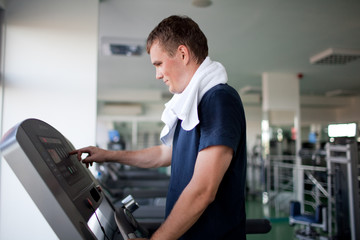 Fototapeta na wymiar Healthy man a treadmill in a sport center
