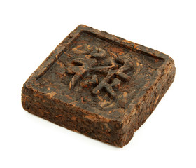 Pressed briquette of green tea with hieroglyphic on white backgr