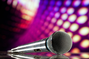 Naklejka premium microphone against purple disco background