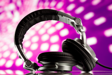 dj headphones against purple disco background