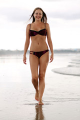 happy woman in bikini walks on a beach