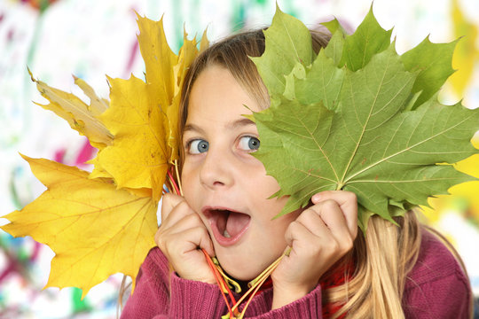 enfant jouant avec des feuilles d'automne