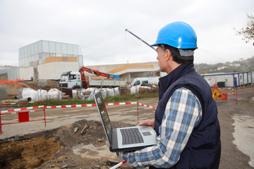 Engineer on construction site with laptop computer