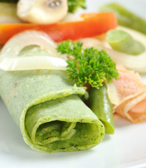 Rolled thin green pancake with parsley and vegetables