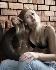Fototapeta na wymiar The sexual blonde against a brick wall.