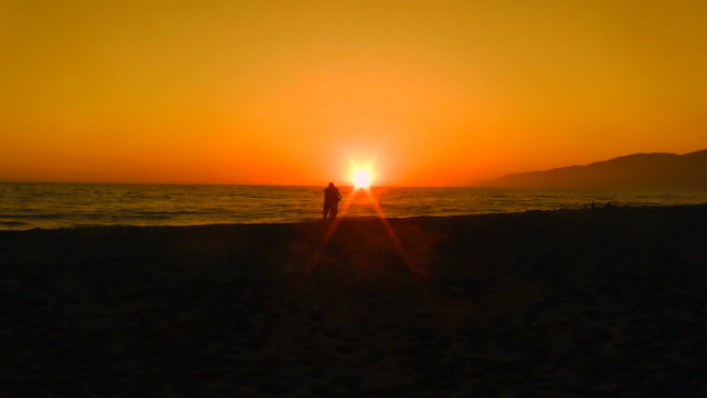 Playful couple on beach at sunset - HD