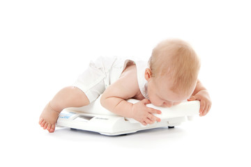 Little baby playing with scales
