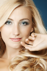 The beautiful girl in a blue dress on a dark blue background