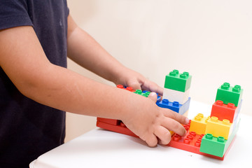 mani di bambino che giocano con le costruzioni