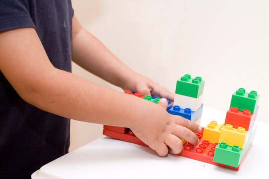 mani di bambino che giocano con le costruzioni