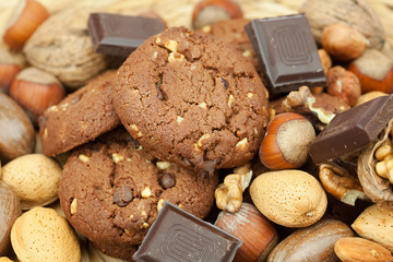 oatmeal cookies, chocolate and nuts on a wicker mat