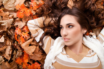 young woman lying on autumn leaves