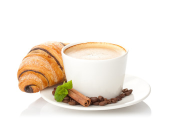 Cup of coffee with coffee beans, cinnamon sticks and chocolate c