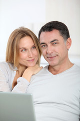 Happy couple surfing on internet at home