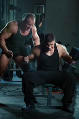 Obraz premium Two bodybuilders training in gym