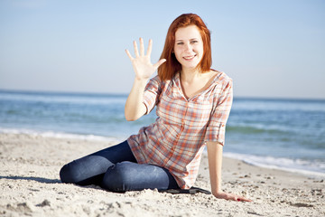 Happy red-haired girl at the beach.