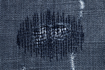 very detailed hi res photo of denim with stiched darned holes
