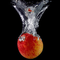 Red apple splash in water isolated on black background