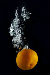 Orange splash in water isolated on black background