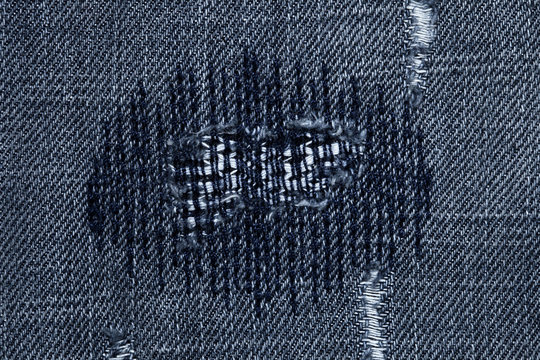 very detailed hi res photo of denim with stiched darned holes