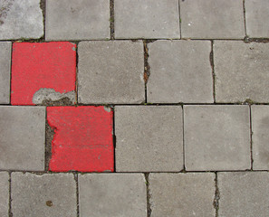 2 red tilesembedded in pavement sidewalk