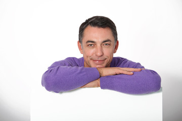 Smiling man with white message board