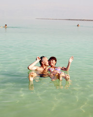 A man and a woman bathing in the Dead Sea