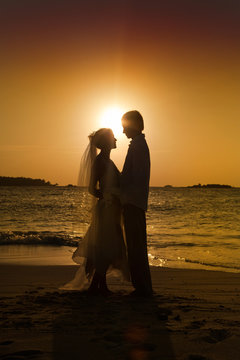 Bride and groom on beach.