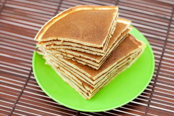 Pancakes on a plate on a bamboo mat