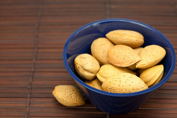 almonds in a bowl on a bamboo mat