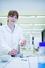 pretty, young female researcher lighting up a burner in a lab (s