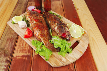 savory on wooden table: two fried fish