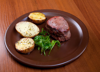 Grilled beef on white plate with potatoes