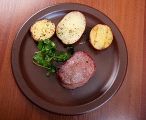 Grilled beef on white plate with potatoes