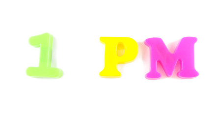 1 pm written in fridge magnets on white background