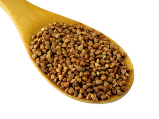 Uncooked buckwheat in a natural wood spoon, isolated